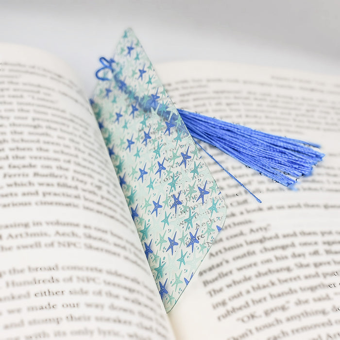 an open book with a tassel on top of it