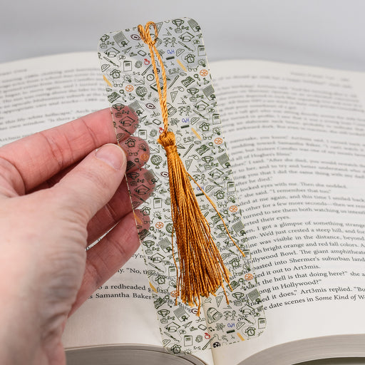 a person holding an open book with a tassel on it