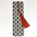 a bookmark with a red tassel and skulls on it