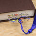 a book with a bookmark and a tassel on a table