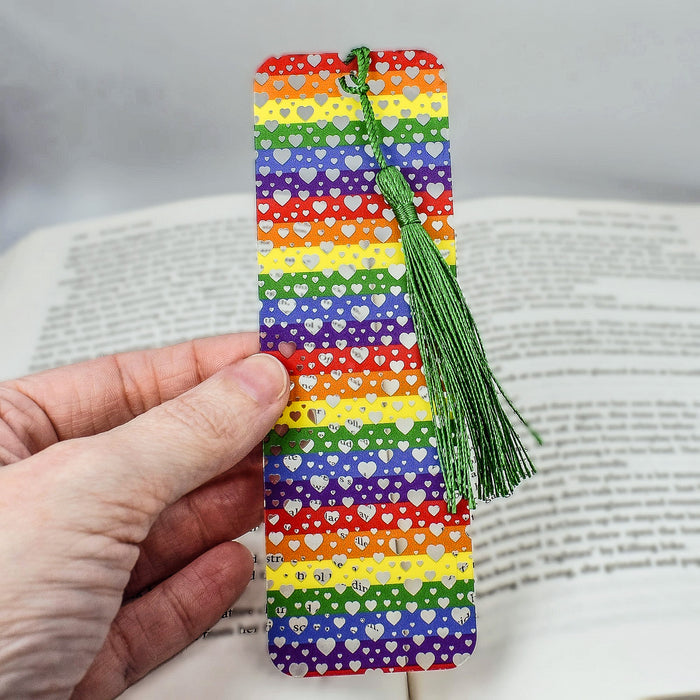 a person holding a bookmark with a green tassel