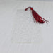 a red tassel is laying on a white sheet