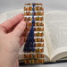 a hand holding a bookmark made out of books