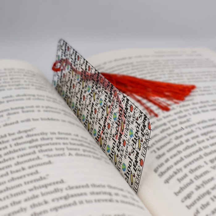 an open book with a red tassel on top of it