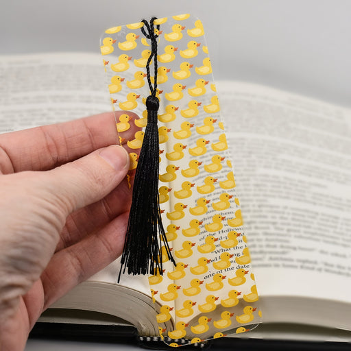 a person holding a bookmark with rubber ducks on it