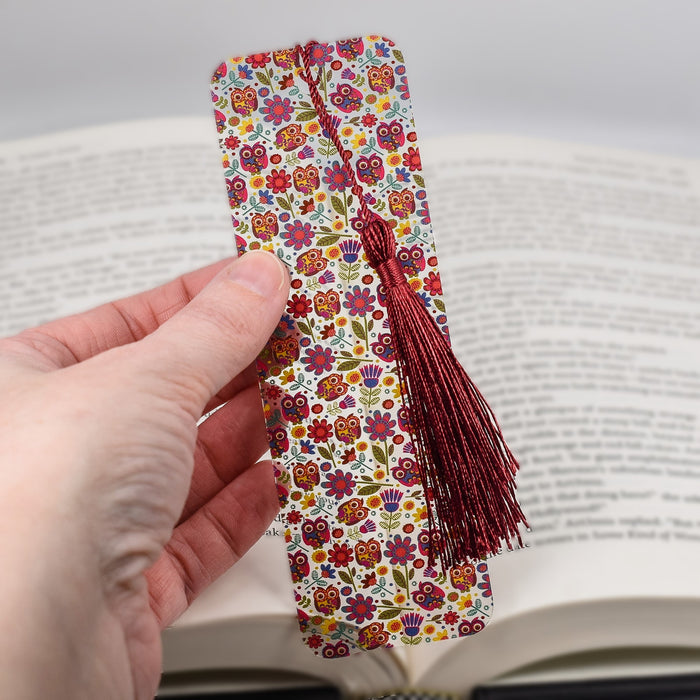 a hand holding a bookmark in front of an open book