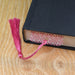 a book with a pink tassel on top of it