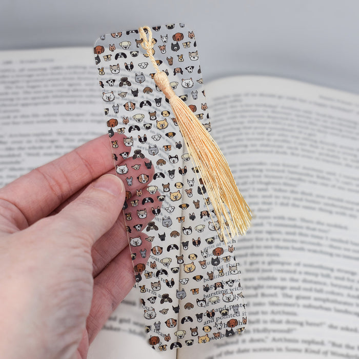 a person holding a bookmark with a book in the background