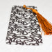 a black and white bookmark with a tassel