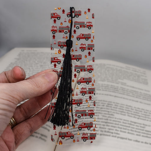 a person holding a bookmark with a book in the background