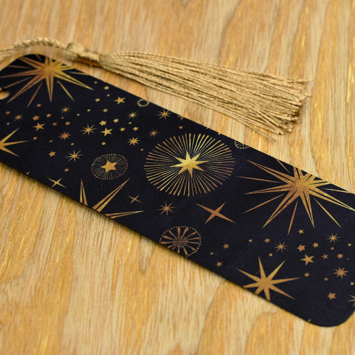a black and gold bookmark with stars on it