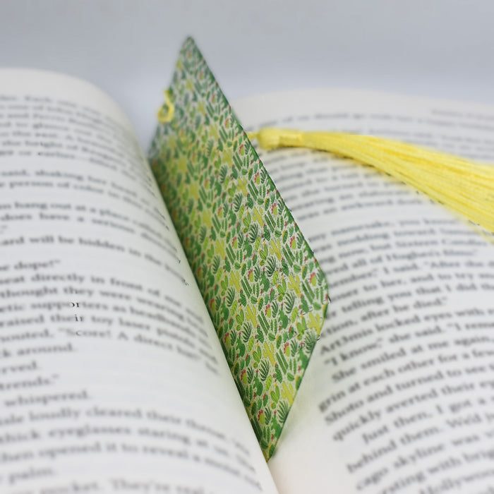 an open book with a yellow tassel on top of it