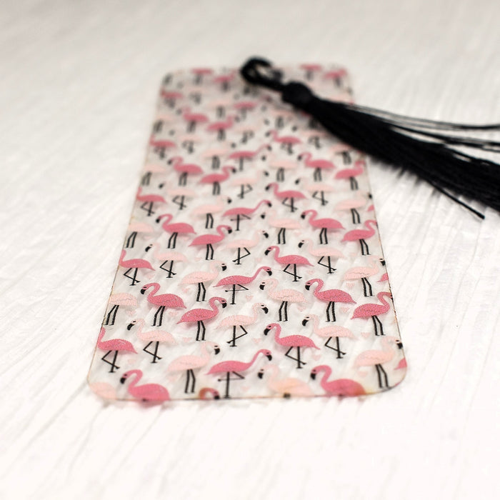 a bookmark with pink flamingos and black tassels