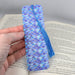 a hand holding a book with a blue tie on it