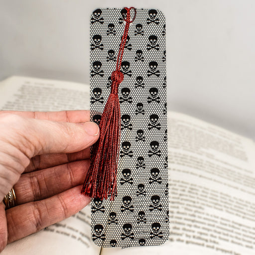 a person holding a bookmark with skulls on it