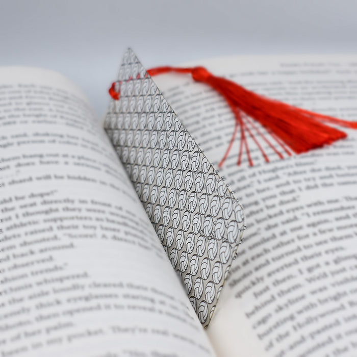 an open book with a red tassel on top of it