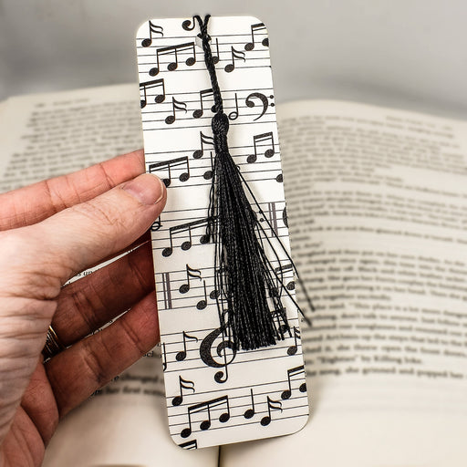 a hand holding a bookmark with musical notes on it