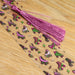 a wooden table topped with a purple tassel